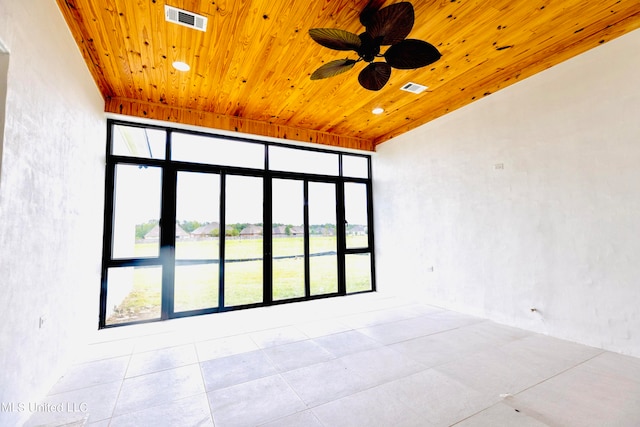 tiled spare room featuring a wealth of natural light, wood ceiling, and ceiling fan