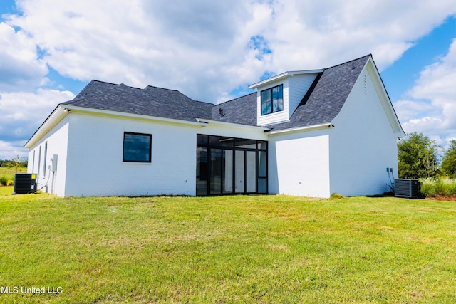 back of house featuring cooling unit, a lawn, and a sunroom