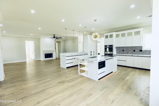 138 Genoa Dr, Madison, MS 39110 - kitchen with open shelves, ornamental molding, a center island with sink, backsplash, and open floor plan