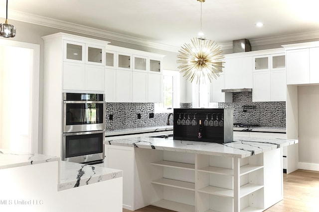 kitchen featuring white cabinets, a kitchen island, and hanging light fixtures