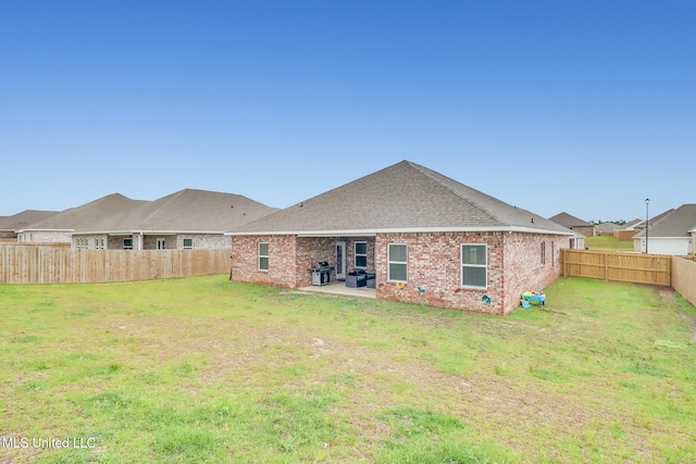 back of house featuring a patio area and a lawn