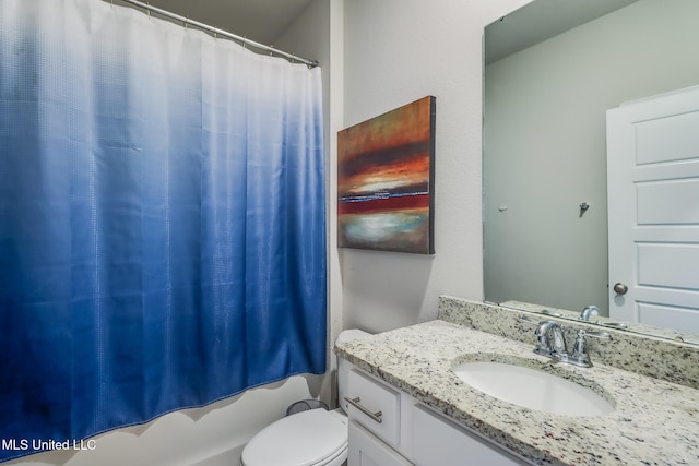 bathroom with curtained shower, vanity, and toilet