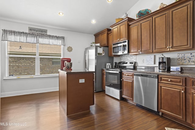 13703 Windwood Dr, Gulfport, MS 39503 - kitchen featuring appliances with stainless steel finishes, dark wood-type flooring, a kitchen island, recessed lighting, and baseboards