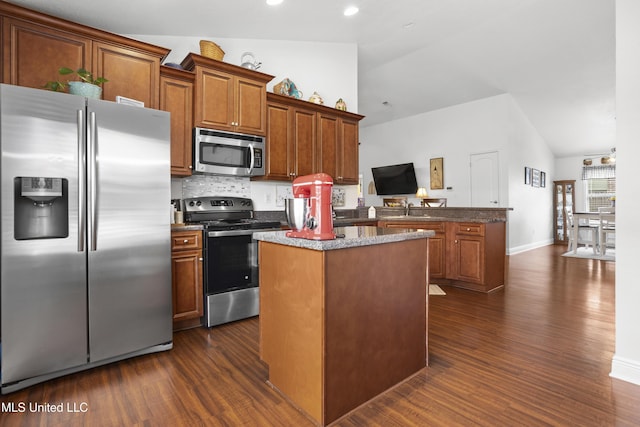 13703 Windwood Dr, Gulfport, MS 39503 - kitchen with appliances with stainless steel finishes, vaulted ceiling, a center island, dark wood finished floors, and a sink