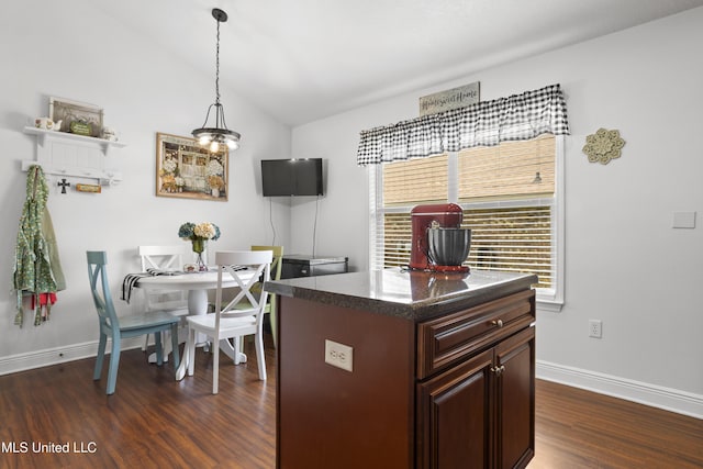 13703 Windwood Dr, Gulfport, MS 39503 - kitchen with dark wood-style flooring, baseboards, lofted ceiling, dark countertops, and pendant lighting