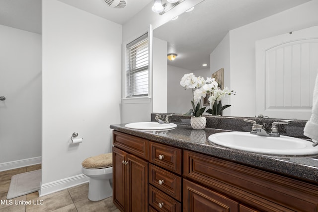 13703 Windwood Dr, Gulfport, MS 39503 - full bath with double vanity, toilet, tile patterned flooring, and baseboards