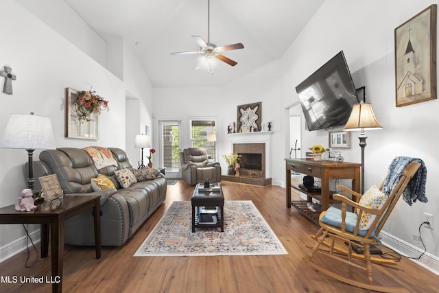 13703 Windwood Dr, Gulfport, MS 39503 - living room featuring ceiling fan, wood finished floors, a tile fireplace, baseboards, and high vaulted ceiling