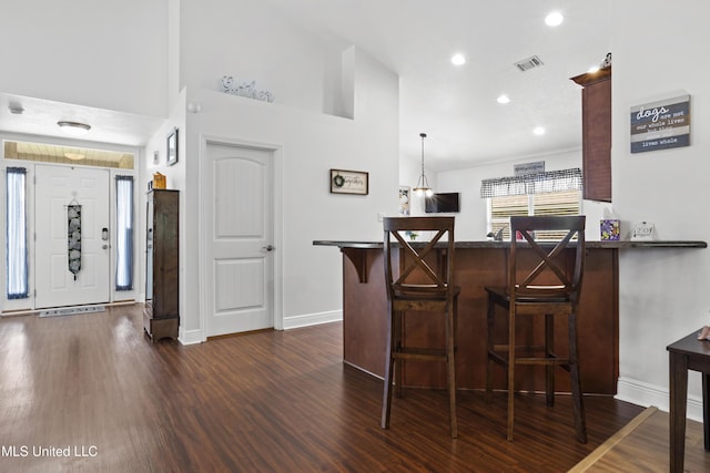 13703 Windwood Dr, Gulfport, MS 39503 - kitchen featuring dark wood-style floors, a breakfast bar area, baseboards, and recessed lighting