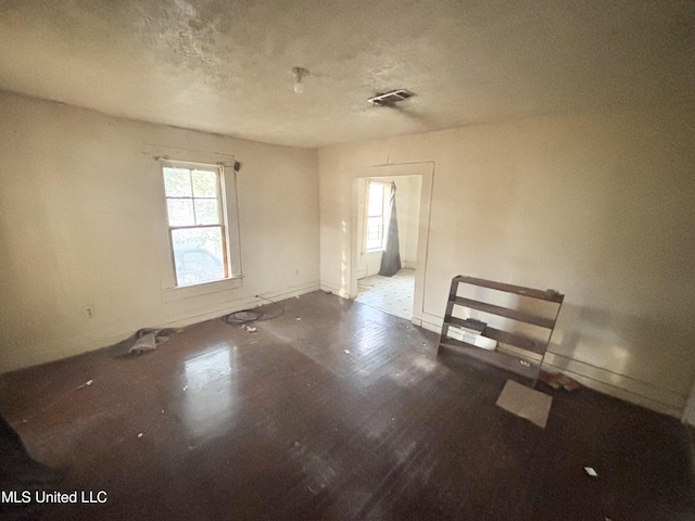 spare room featuring baseboards, visible vents, and a textured ceiling