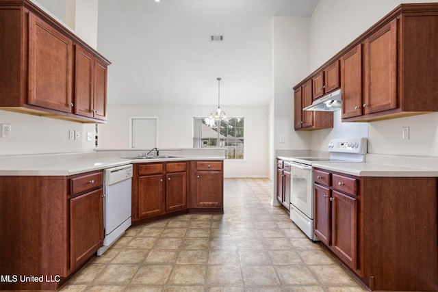 kitchen featuring white appliances, sink, kitchen peninsula, pendant lighting, and an inviting chandelier