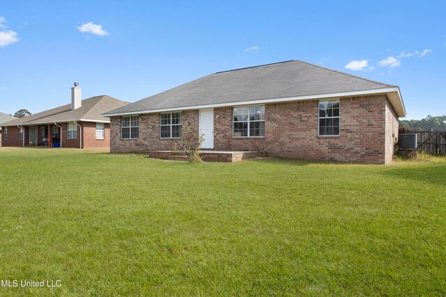 back of property featuring a yard and central AC