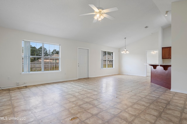 empty room featuring high vaulted ceiling and ceiling fan with notable chandelier