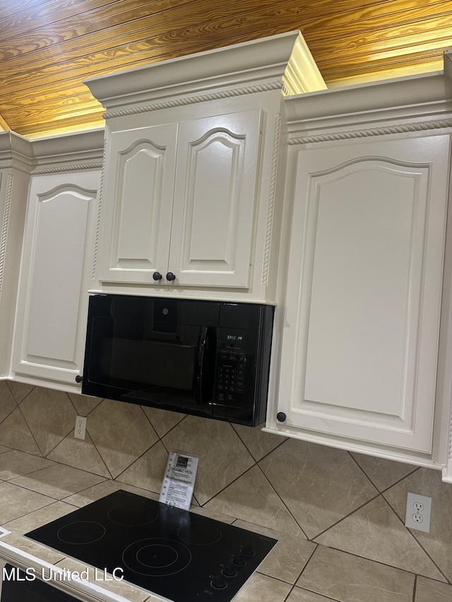 423 Grant Fox Dr, Brandon, MS 39047 - kitchen view of black microwave, white cabinetry, backsplash, and range