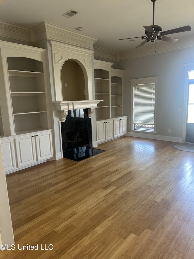 423 Grant Fox Dr, Brandon, MS 39047 - unfurnished living room featuring ornamental molding, a premium fireplace, light wood-style flooring, a ceiling fan, and baseboards