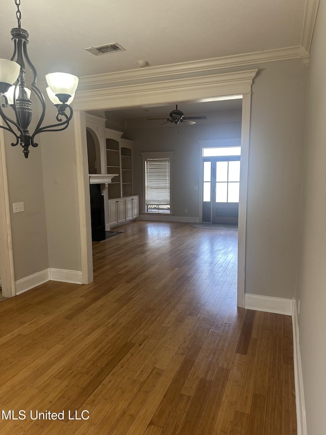 423 Grant Fox Dr, Brandon, MS 39047 - unfurnished living room featuring crown molding, a chandelier, a ceiling fan, baseboards, and wood finished floors