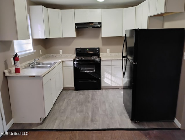 kitchen featuring sink, black appliances, white cabinetry, and light hardwood / wood-style flooring