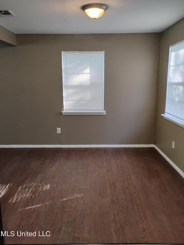 empty room with dark wood-type flooring