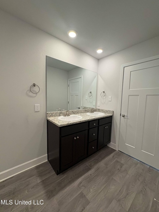 18052 Tiffany Renee Dr, Gulfport, MS 39503 - bathroom featuring double vanity, wood finished floors, baseboards, and recessed lighting
