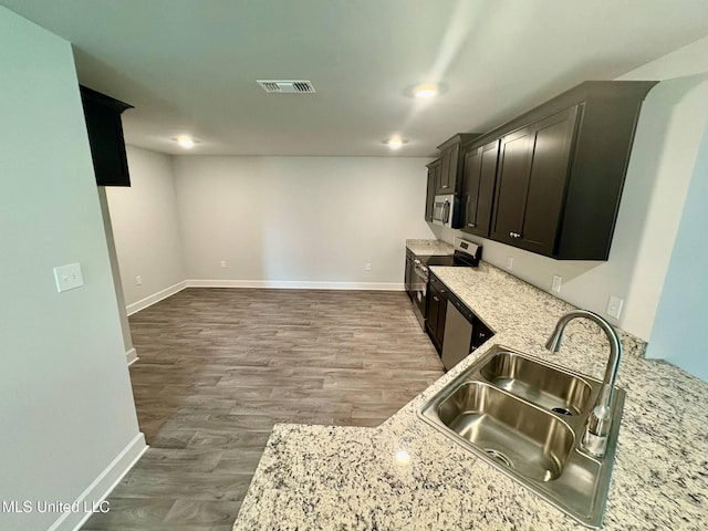 18052 Tiffany Renee Dr, Gulfport, MS 39503 - kitchen featuring a sink, appliances with stainless steel finishes, baseboards, light stone countertops, and wood finished floors