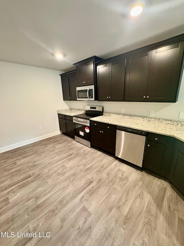18052 Tiffany Renee Dr, Gulfport, MS 39503 - kitchen with stainless steel appliances, light wood-style floors, baseboards, and light stone countertops