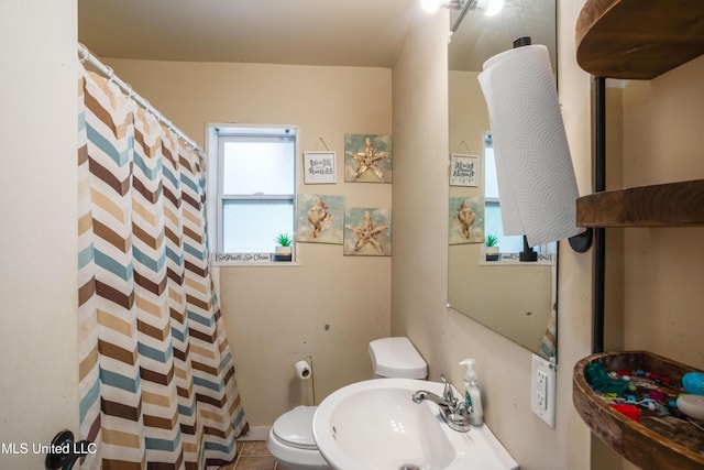 full bath with a sink, toilet, and curtained shower