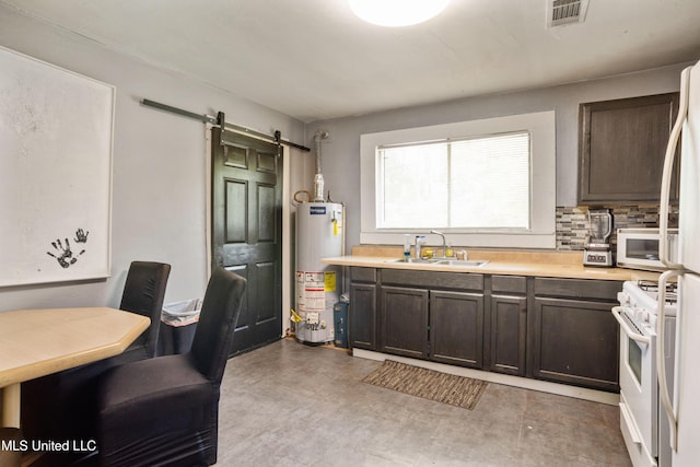kitchen featuring visible vents, dark brown cabinets, a barn door, gas water heater, and a sink