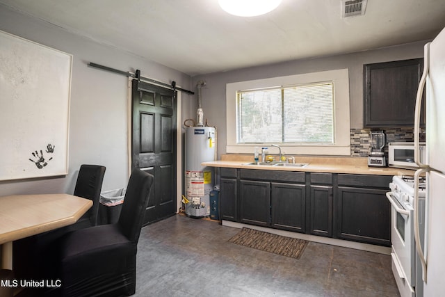 kitchen featuring visible vents, white appliances, a barn door, a sink, and water heater