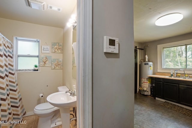 bathroom featuring water heater, toilet, a sink, and visible vents