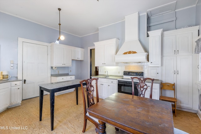 kitchen with range with electric cooktop, white cabinetry, light wood finished floors, decorative light fixtures, and custom range hood