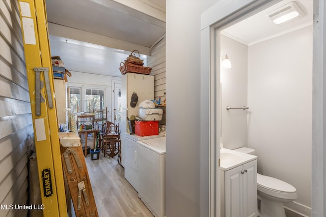 bathroom with visible vents, toilet, vanity, separate washer and dryer, and wood finished floors