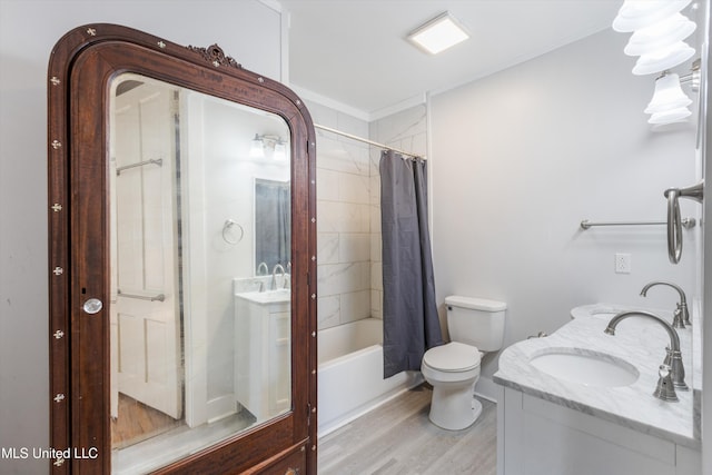 full bath with double vanity, shower / tub combo, toilet, wood finished floors, and a sink