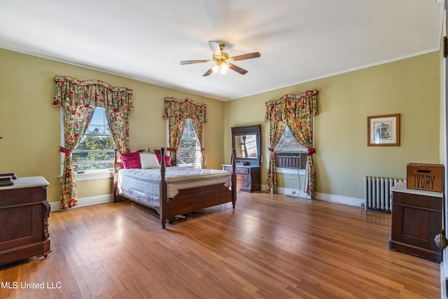 bedroom featuring radiator, baseboards, and wood finished floors