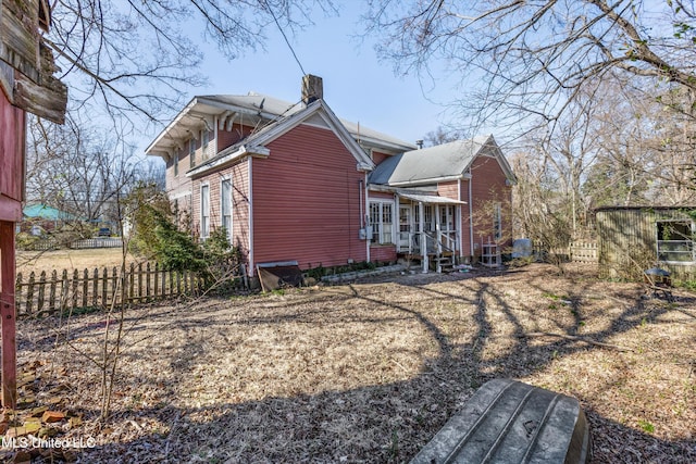 exterior space featuring a chimney and fence