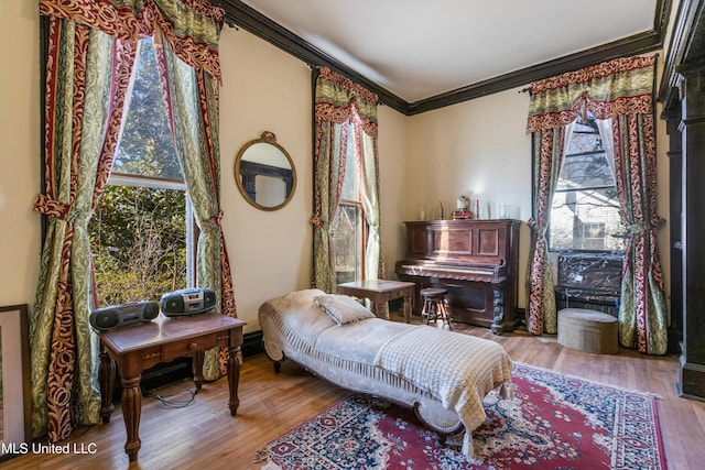 sitting room featuring ornamental molding and wood finished floors