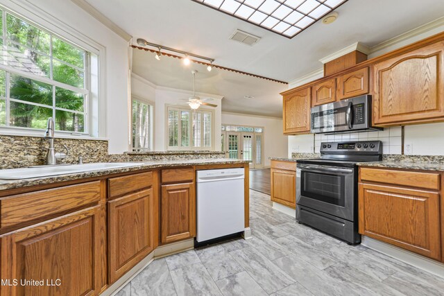 7635 Fairway Dr, Diamondhead, MS 39525 - kitchen with appliances with stainless steel finishes, a sink, ornamental molding, tasteful backsplash, and healthy amount of natural light