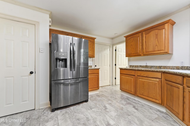7635 Fairway Dr, Diamondhead, MS 39525 - kitchen with stainless steel fridge, brown cabinetry, light marble finish flooring, light stone countertops, and crown molding