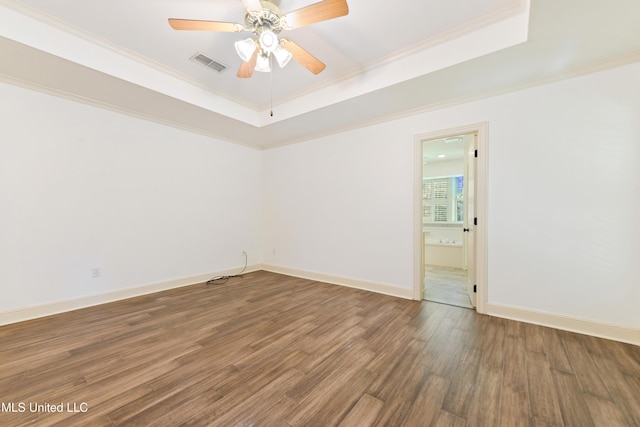 7635 Fairway Dr, Diamondhead, MS 39525 - unfurnished room featuring a tray ceiling, wood finished floors, ornamental molding, ceiling fan, and baseboards