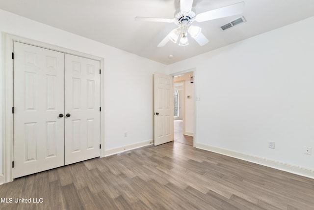 7635 Fairway Dr, Diamondhead, MS 39525 - unfurnished bedroom featuring wood finished floors, baseboards, a closet, and ceiling fan