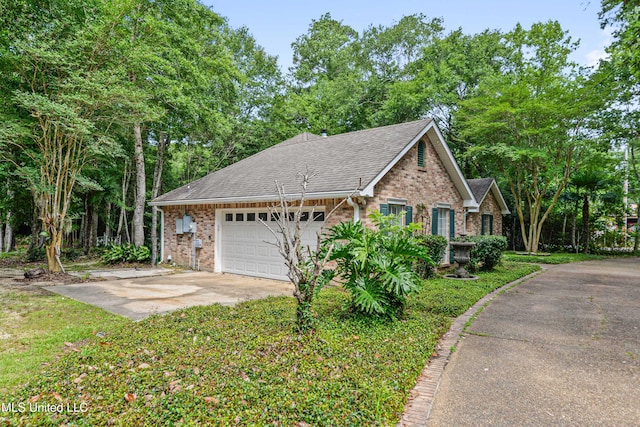 7635 Fairway Dr, Diamondhead, MS 39525 - view of home's exterior with brick siding, a garage, driveway, and roof with shingles