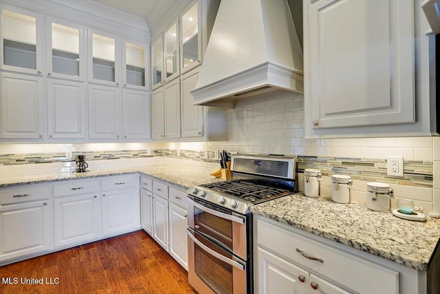 244 Hidden Hills Pkwy, Brandon, MS 39047 - kitchen with custom range hood, double oven range, white cabinetry, and tasteful backsplash
