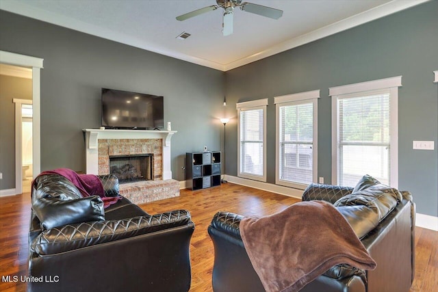 244 Hidden Hills Pkwy, Brandon, MS 39047 - living room with a fireplace with raised hearth, a ceiling fan, plenty of natural light, crown molding, and wood finished floors