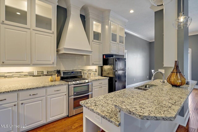 244 Hidden Hills Pkwy, Brandon, MS 39047 - kitchen featuring range with two ovens, custom exhaust hood, freestanding refrigerator, white cabinetry, and crown molding
