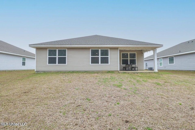 back of property with a yard and a patio