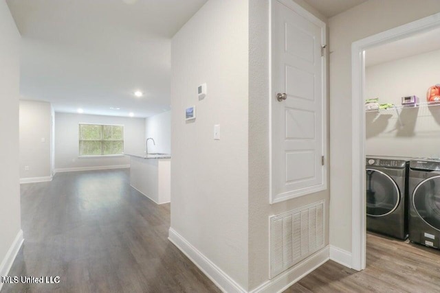 hallway with washer and clothes dryer and wood-type flooring