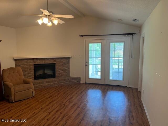 unfurnished living room with dark wood-type flooring, ceiling fan, vaulted ceiling with beams, and a brick fireplace