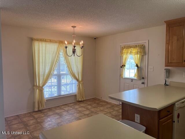 kitchen featuring kitchen peninsula, a textured ceiling, a chandelier, white dishwasher, and pendant lighting