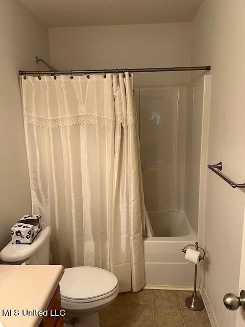 full bathroom with toilet, tile patterned flooring, shower / tub combo, vanity, and a textured ceiling