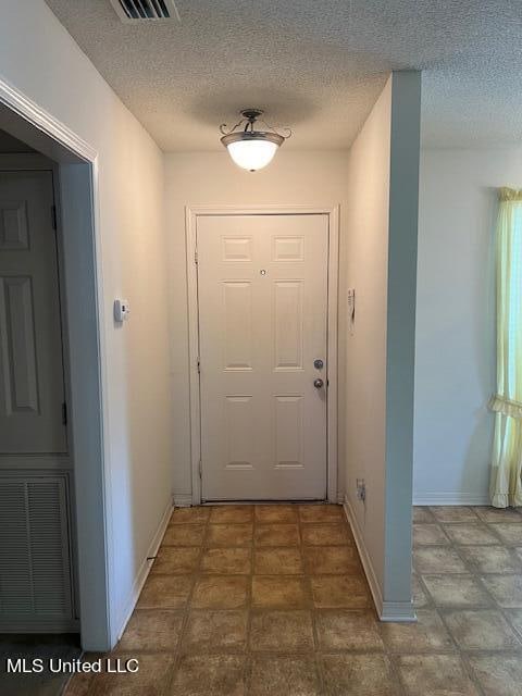 doorway featuring a textured ceiling