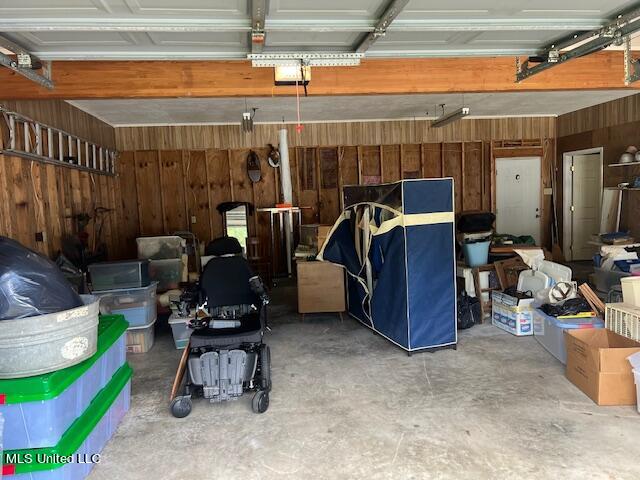 garage featuring a garage door opener and wood walls