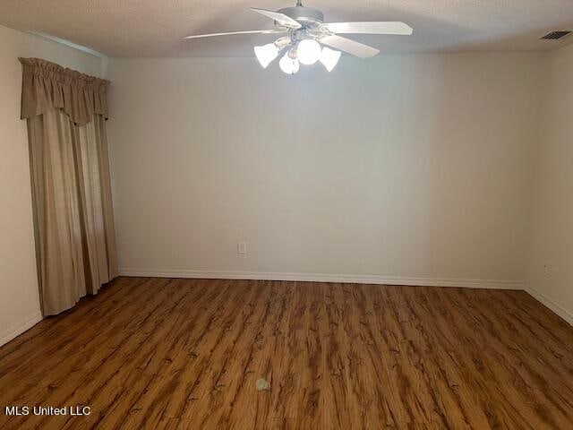 empty room with ceiling fan and dark hardwood / wood-style floors